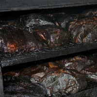 <p>Smoked pork and beef brisket in a giant smoker at Big W&#x27;s Roadside BBQ.</p>