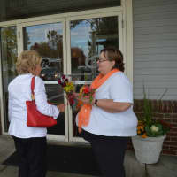 <p>Raeann McLaren presents two shoppers with free bouquets, courtesy of City Line Florist of Trumbull.</p>