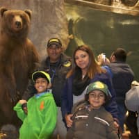 <p>A family poses with a stuffed bear at Bass Pro.</p>