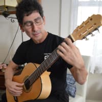<p>Feeling strong and well, Steve Freides plays a number of instruments, including guitar.</p>