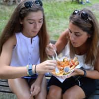 <p>Juliana Mercurio, left, and her mom, Tish Mercurio, both of Allendale, enjoying a Thai combo platter from the Aroy-D truck.</p>