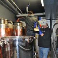 <p>The building is outfitted to brew several beers at once. Commander and Nunes tend to their newest batch.</p>