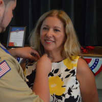 <p>Elizabeth Fine receiving an Eagle Scout pin from her son.</p>