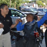 <p>Courtney Machiri celebrates after riding down the sidewalk in front of the American Legion Hall.</p>