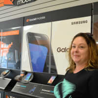<p>Old Boost Mobile: Lisa Lombardo, account executive, standing by one of the sales walls.</p>