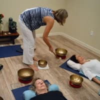 <p>Mary Ann Gebhardt playing singing bowls while leading a guided visualization.</p>