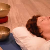 <p>Sheila Heinz of Mahwah with singing bowls in a yoga nidra class designed to induce deep relaxation.</p>