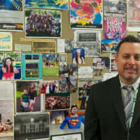 <p>Yorktown High Principal Joe DeGennaro in front of his bulletin board in his office.</p>
