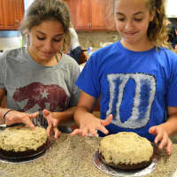 <p>Students work with a cookie dough filling as part of making a ganache cake.</p>