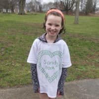 <p>A soaking wet little girl is still all smiles in her Sandy Hook T-shirt after Saturday&#x27;s kids race.</p>