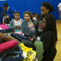 <p>A volunteer helps kids with clothes at Saturday&#x27;s event.</p>