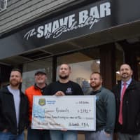 <p>Outside The Shave Bar for a pre-shave pose holding a symbolic check for the $3,792 Hillsdale police raised for cancer research during No-Shave November.</p>