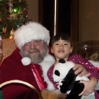 <p>A young girl visits with Santa and his Elf.</p>