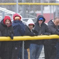 <p>Spectators try to keep warm on a chilly spring day.</p>