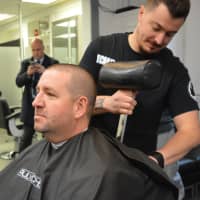 <p>Det. Sgt. Adam Hampton halfway through his shave experience with barber Michael Aspinwall.</p>