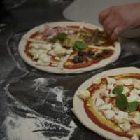 <p>A chef prepares Margherita pizza (right), and the restaurant&#x27;s popular &#x27;Four Season&#x27; Pizza - with mushrooms, olives, mozzerella and artichokes.</p>