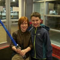 <p>A boy holds a light saber as he and a buddy head in to see &quot;Star Wars: The Force Awakens&quot; on Thursday evening in Stamford.</p>