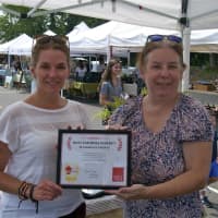 <p>Daily Voice Managing Editor Karen Tensa (R) presents DVlicious first-place award to Lori Cochran-Dougall, Executive Director of the Westport Farmers Market.</p>