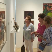 <p>Visitors check out the work of WCSU faculty members.</p>