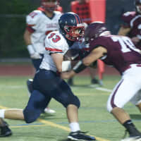 <p>Eastchester&#x27;s John Guido (33) runs into a defender Friday at Harrison. Guido finished with two TDs.</p>