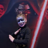 <p>A girl heads in to see Star Wars with a painted face.</p>
