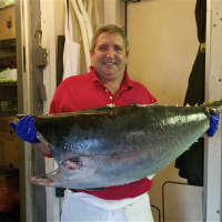 <p>Manager Scott Bennett holds up a fresh tuna.</p>