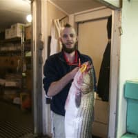 <p>Assistant Manager Zachary Redin gets set to slice up a striped bass.</p>