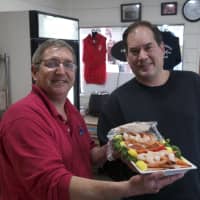 <p>Rowayton Seafood manager Scott Bennett hands over a shrimp platter to a happy customer on Christmas Eve.</p>