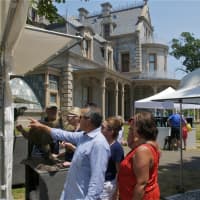 <p>Visitors view artwork at the Norwalk Art Festival on Sunday in the shadow of the Lockwood-Mathews Mansion.</p>