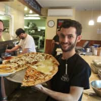 <p>Froggy&#x27;s owners John (L) and Bob Russo show off one of their most popular sandwiches - the Goliath - and some of their pizza.</p>