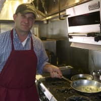 <p>Muscoot Manager Arber Muriqi starts a dish in the kitchen.</p>