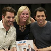 <p>Jonathan (L) and Drew Scott (R) pose with a fan at Monday&#x27;s book signing.</p>
