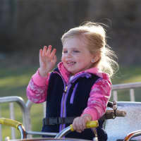 <p>A young girl waves to her mom at the carnival in Trumbull.</p>