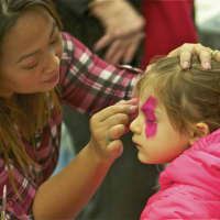 <p>A girl gets her face painted.</p>