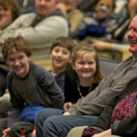 <p>A family watches a show at Saugatuck Elementary.</p>