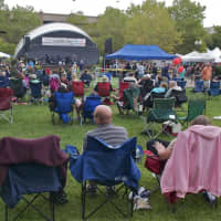 <p>A crowd gathers on the grass to watch a live performance from the Doug Wahlberg Band.</p>