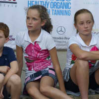 <p>Some of the child models watch the action while waiting for their turn to walk the runway.</p>
