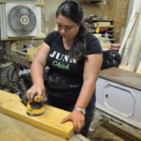 <p>Cheryl Demartini sanding in her wood shop at Junk Chick Designs.</p>