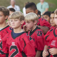 <p>Players watch introductions at a pep rally. </p>
