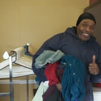 <p>A grateful man finds clothing items at the mission&#x27;s giveaway.</p>