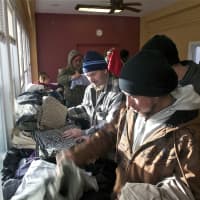 <p>Men look through donated clothing at the Bridgeport Rescue Mission on Thursday.</p>