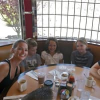 <p>A happy family of five enjoys a meal at the Red Line Diner.</p>