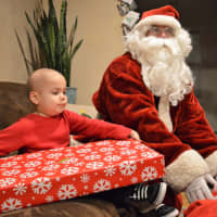 <p>Inside his house, Alex opens his first present from Santa.</p>