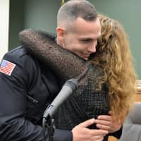 <p>An emotionally overcome Patti Rooney hugs her son, Corey Rooney, Hillsdale&#x27;s newest patrolman, after pinning on his badge.</p>