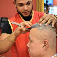<p>Stylist Vlady Garcia of New Milford works on a client at Cache Latino in Bergenfield. Garcia hails from Santo Domingo.</p>