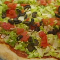 <p>Salad pizza from Goodfellas sports black olives, onions and tomatoes, with balsamic vinaigrette on the side.</p>