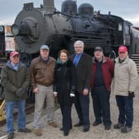 <p>The group stands in front of one of the oldest engines on the site.</p>
