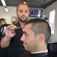 <p>The Shave Bar &amp; Barbershop owner Evan Vidal cuts Ali Poury&#x27;s hair in the Broadway shop.</p>