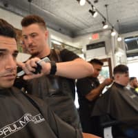 <p>Michael Aspinwall with a client at The Shave Bar and Barbershop in Hillsdale.</p>