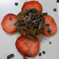 <p>Raw vegan chocolate mousse with strawberry slices and chocolate pieces.</p>